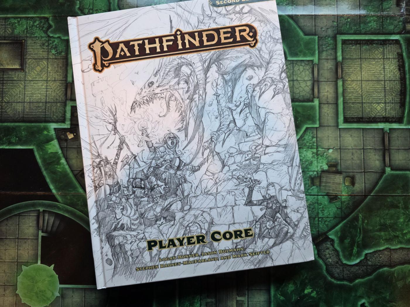 The Pathfinder Player Core with its pencil-sketch cover, on a green dungeon battle mat