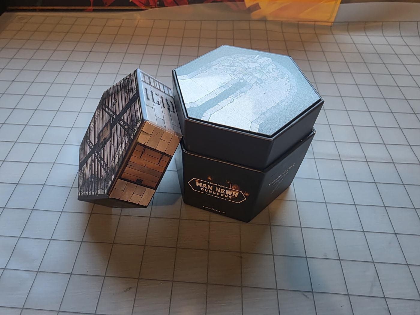 The Man Hewn Dungeons hexagonal box with a tile on its lid