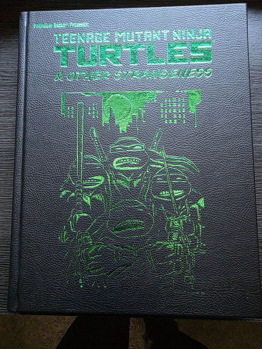 The faux-leather special edition cover, with the title and the four Turtles in green foil