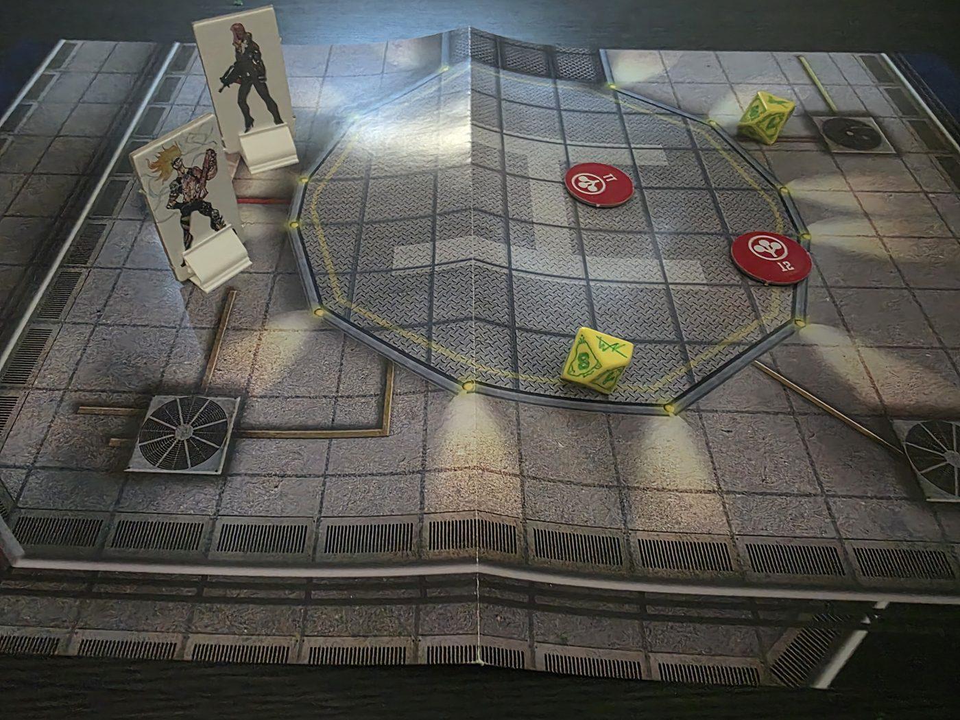 Two standees, two tokens and two yellow Edgerunners dice on a rooftop flip map from the box