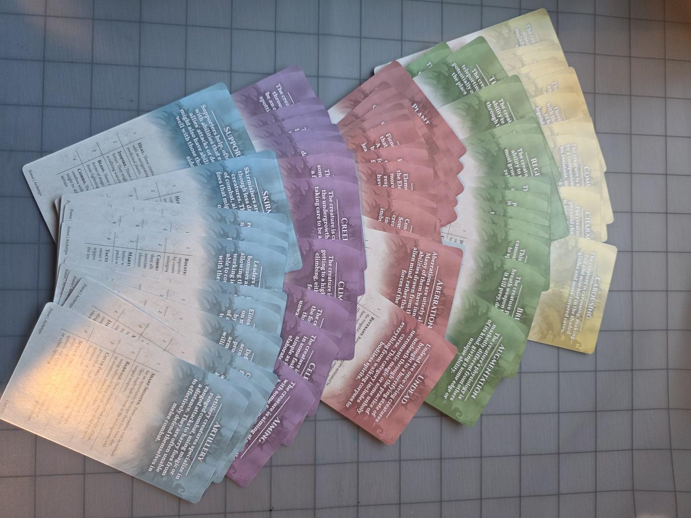 A Forest deck fanned out, its cards color-coded blue, purple, red, green and yellow by category