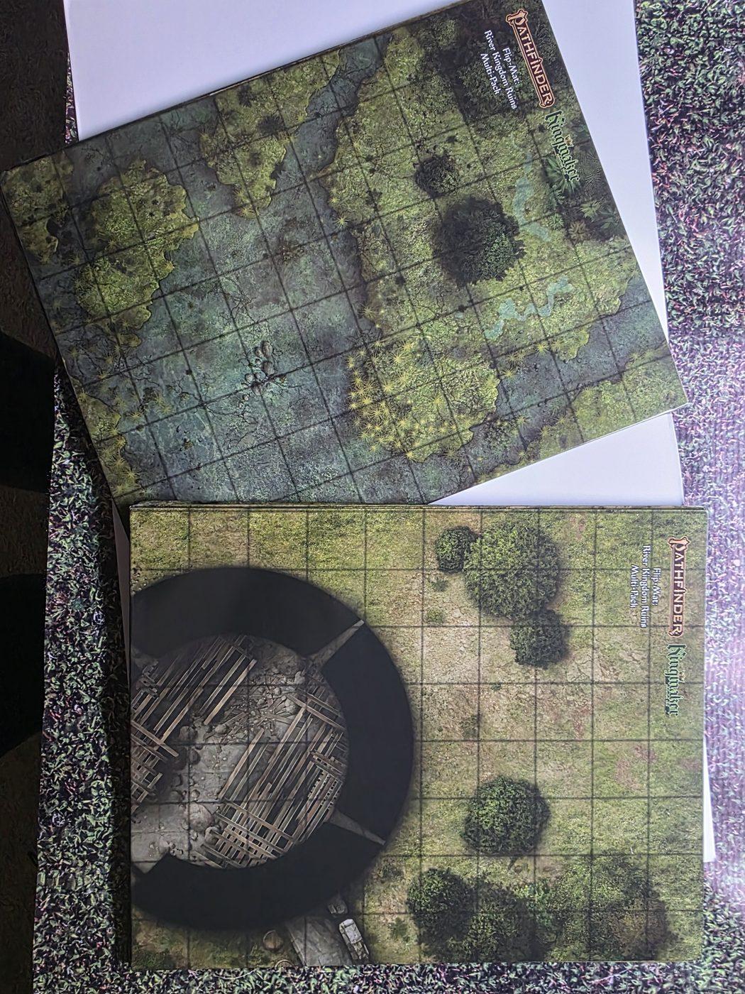 Both Flip-Mats folded: a swamp map and a ruined tower in a grassy field